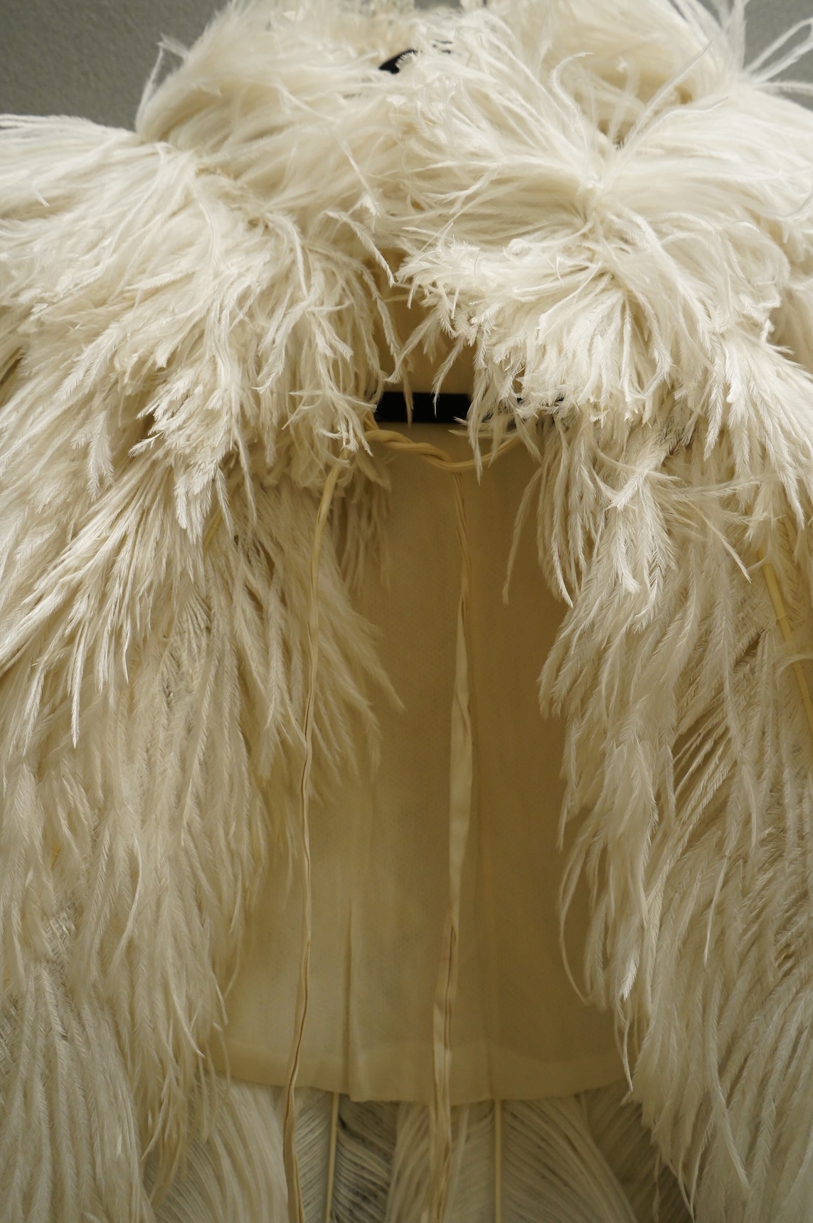 A 1930’s white Ostrich feather evening cape, with small feather stand up collar half lined in georgette.667cm long from top of collar to base. Condition - good - may need professional cleaning.